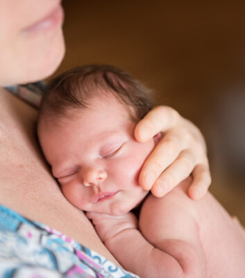newborn baby fast asleep in his mother's arms
